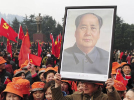 Foto de manifestante com cartaz de Mao Tsé-Tung